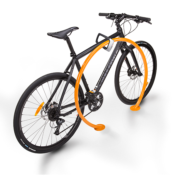 A bike locked to a rack of circle orange shape.